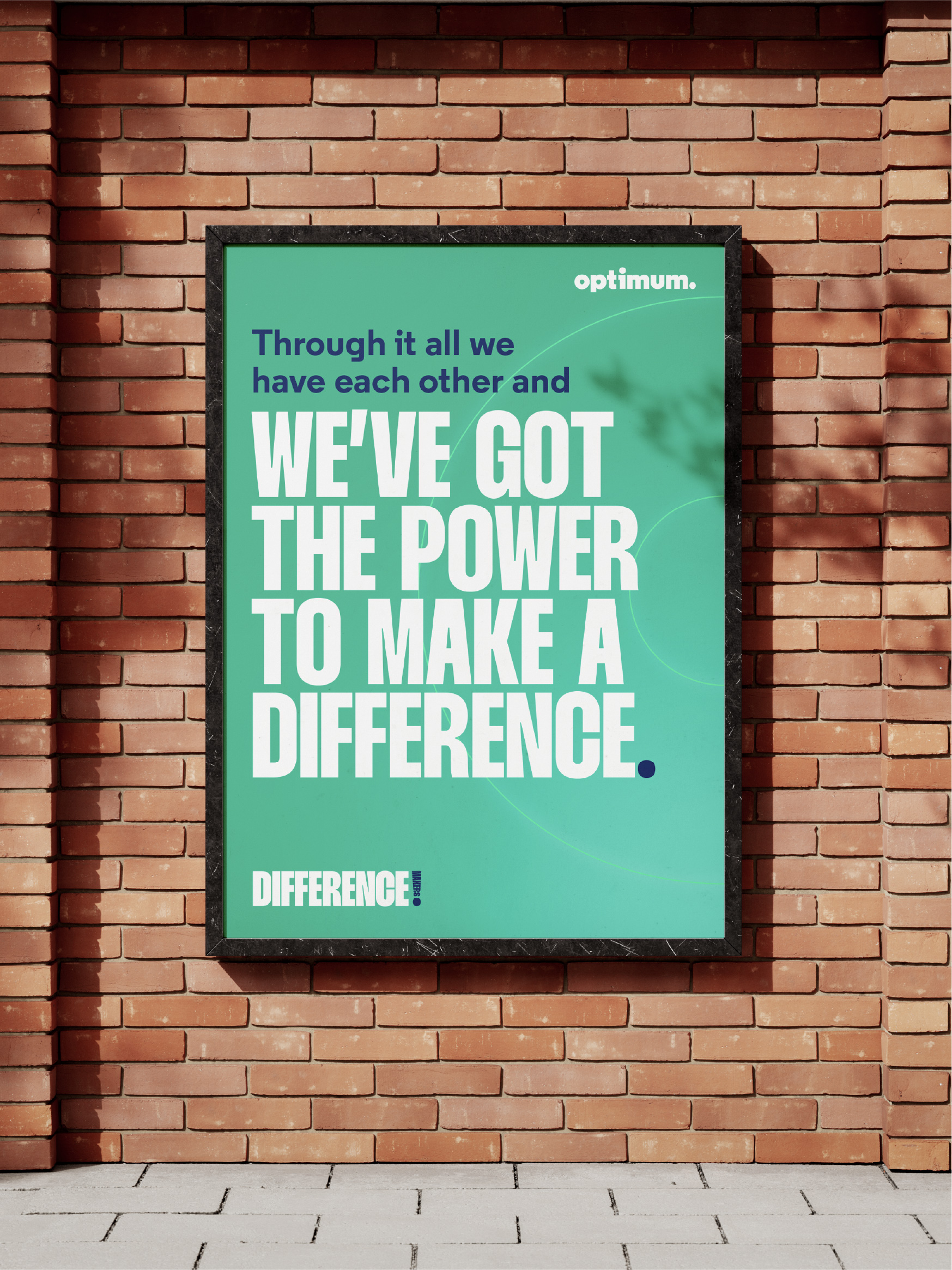 Optimum poster reading 'We've got the power to make a difference' on a brick wall