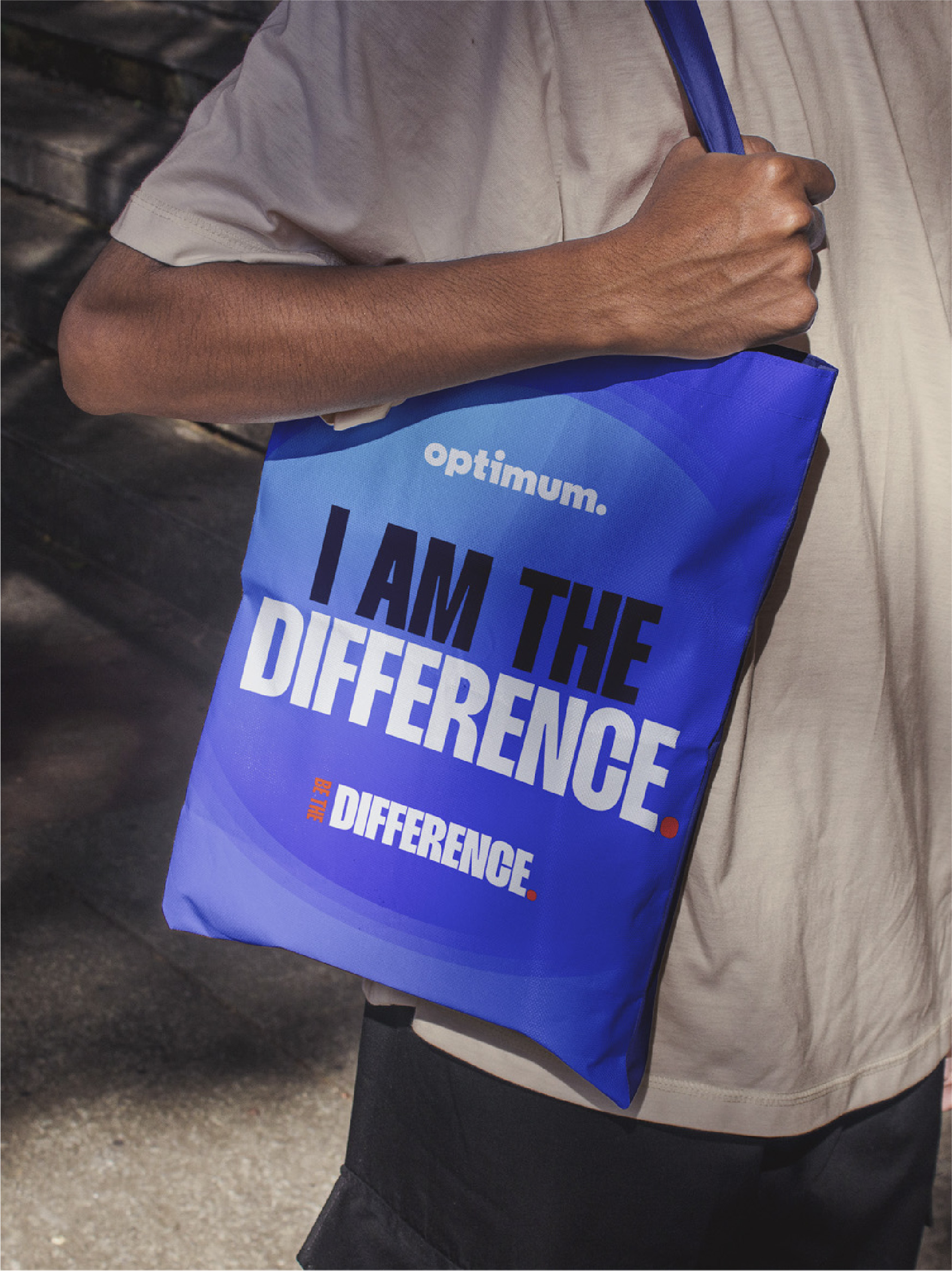 Person carrying an Optimum 'I am the difference' tote bag